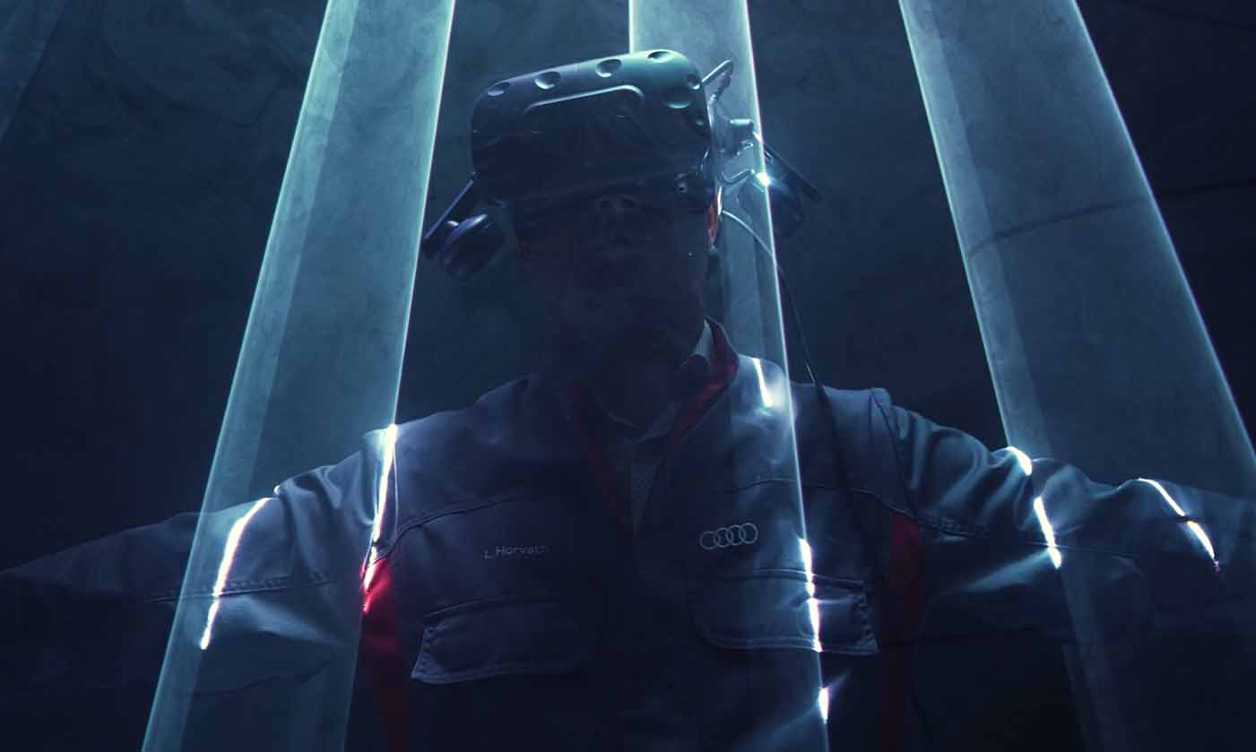Audi Mitarbeiter steht mit VR-Brille in einem dunklen Studio. Beleuchtet nur durch Laserstrahlen.